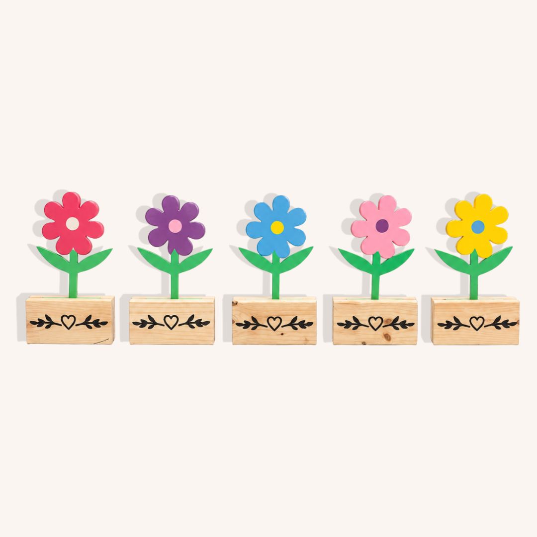 Five colourful wooden flower show jump fillers with green stems and individual custom pine bases on a plain background