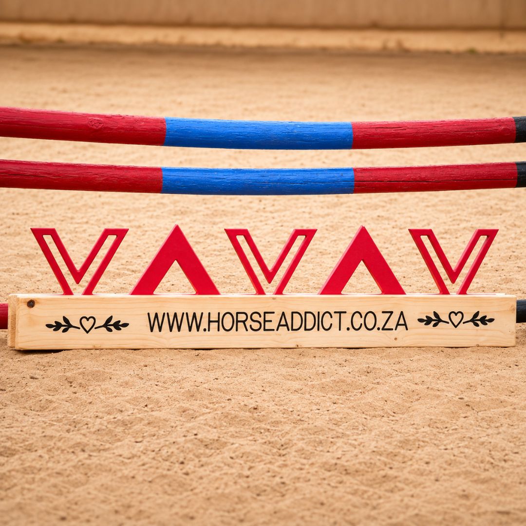 Close front view of blush pink geometric wooden jump filler with pine base beneath coloured arena poles