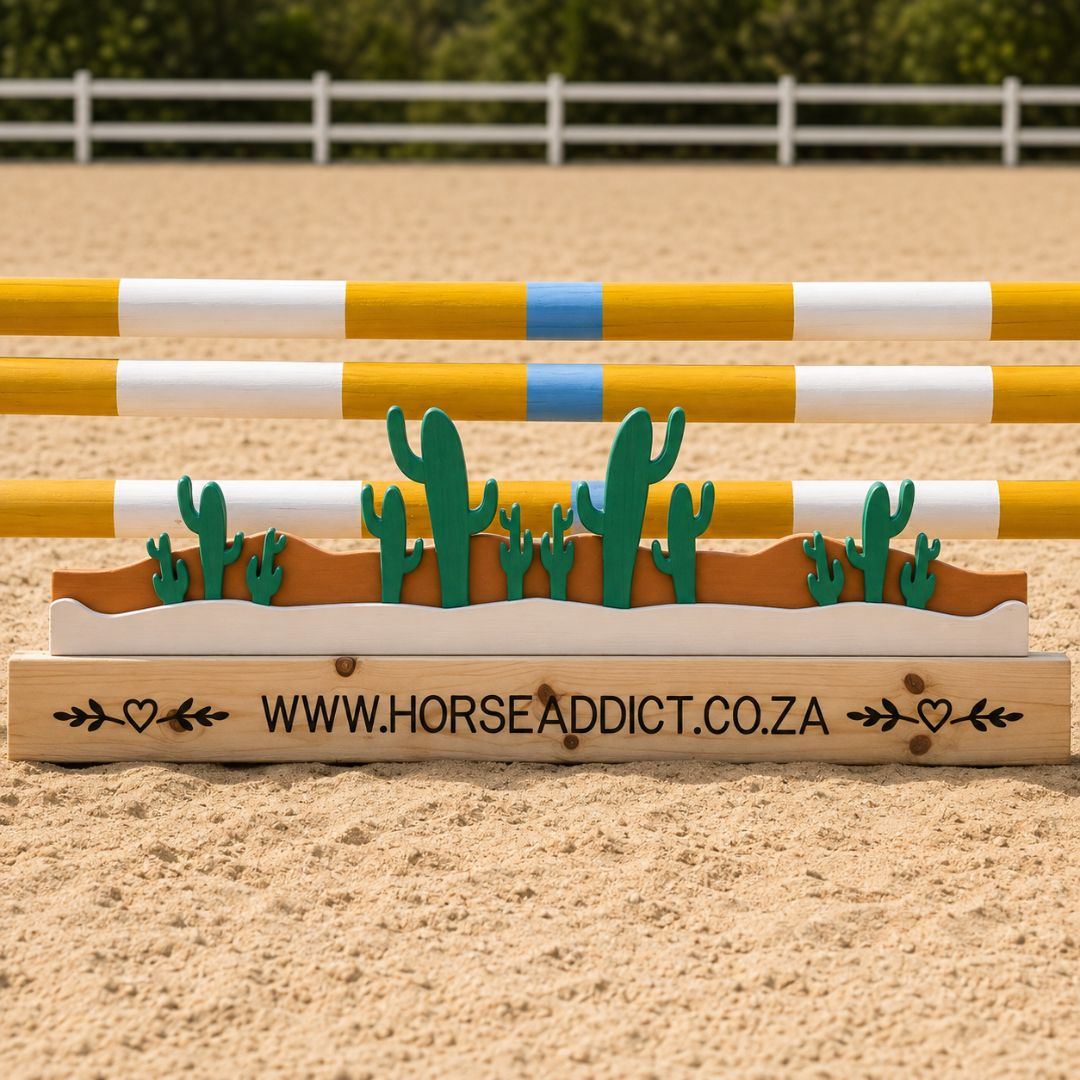 Green cactus wooden jump filler with layered brown desert design beneath yellow and white arena poles